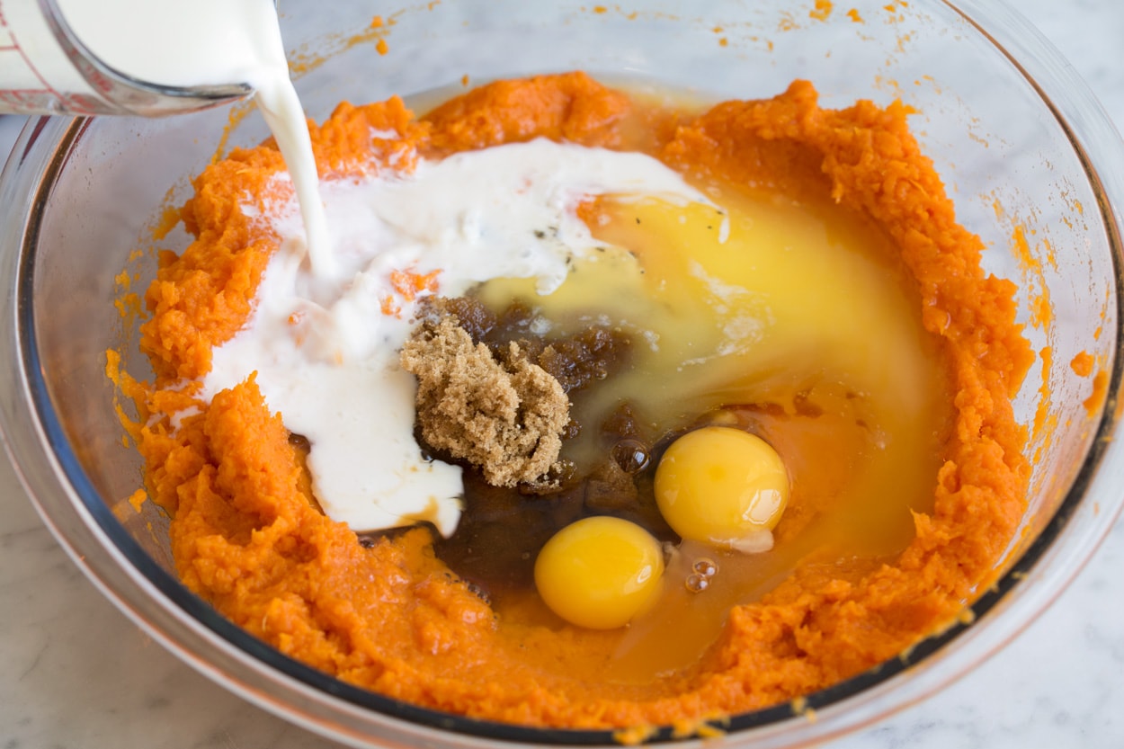 Sweet Potato Casserole Mashed sweet potatoes, milk, eggs, brown sugar, spices in mixing bowl to make sweet potato casserole.
