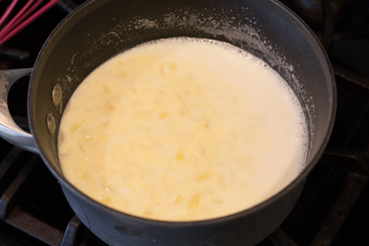 Scalloped Potatoes Adding milk to saucepan for scalloped potatoes.
