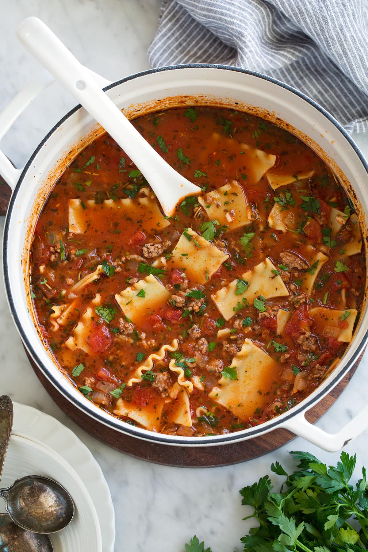 Lasagna Soup Recipe Overhead image of lasagna soup in large white pot set over marble surface.
