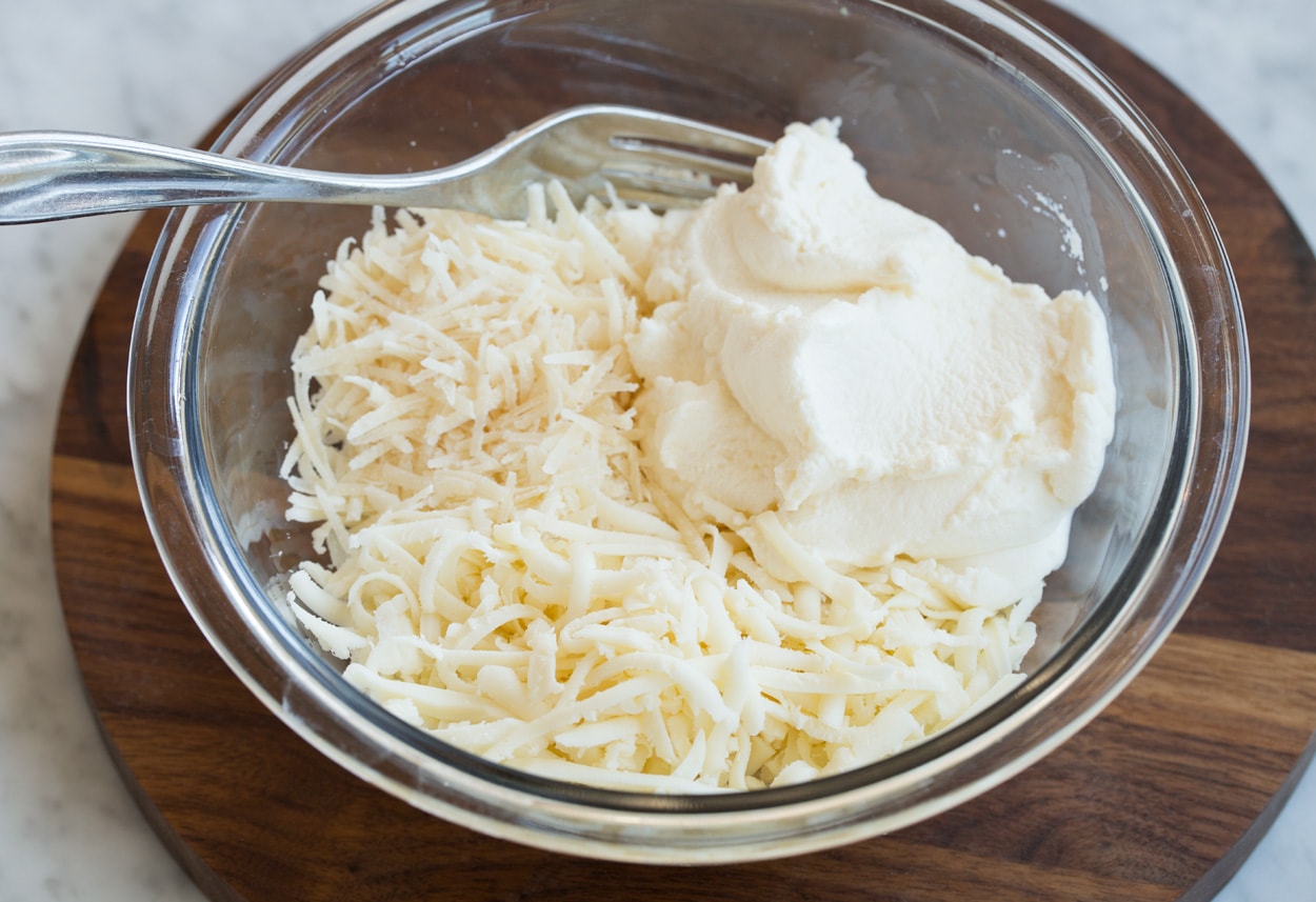 Lasagna Soup Mixing ricotta parmesan and mozzarella in a mixing bowl for lasagna soup.
