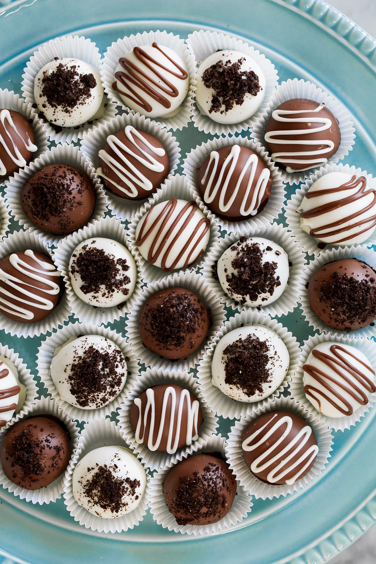 Oreo Balls Oreo Truffles Overhead image of milk chocolate and white chocolate covered oreo balls on a blue platter.