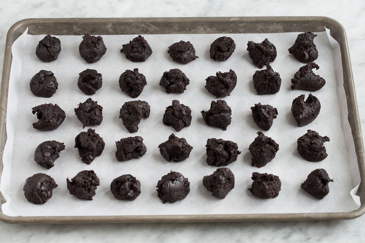 How Should Oreo Truffles Be Stored? Because of the cream cheese they contain Oreo balls should be stored in the refrigerator in an are tight container. Then can sit at room temperature up to 2 hours when serving. Can They be Frozen? Yes, they can be frozen in an airtight container up to 3 months. Thaw in the refrigerator overnight. Uneven portions of oreo truffle mixture divided sitting on a baking sheet.