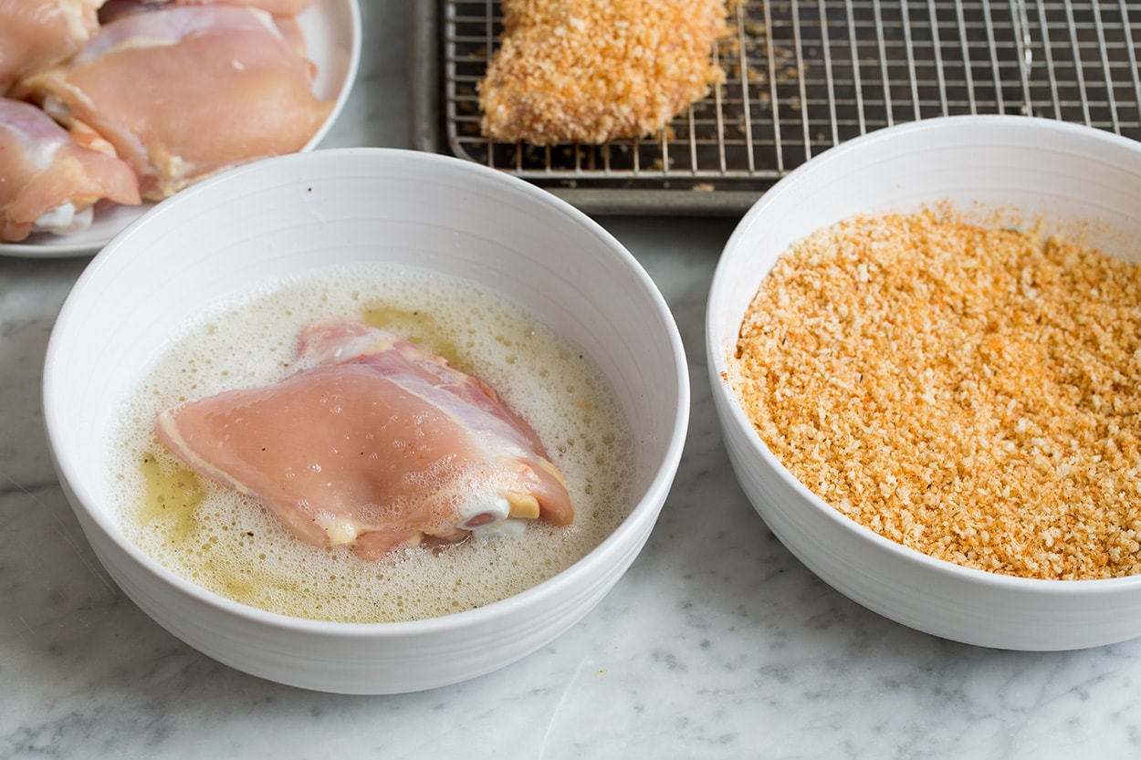 Oven Fried Chicken Dressing chicken thigh in egg white in a bowl and panko for Oven Fried Chicken