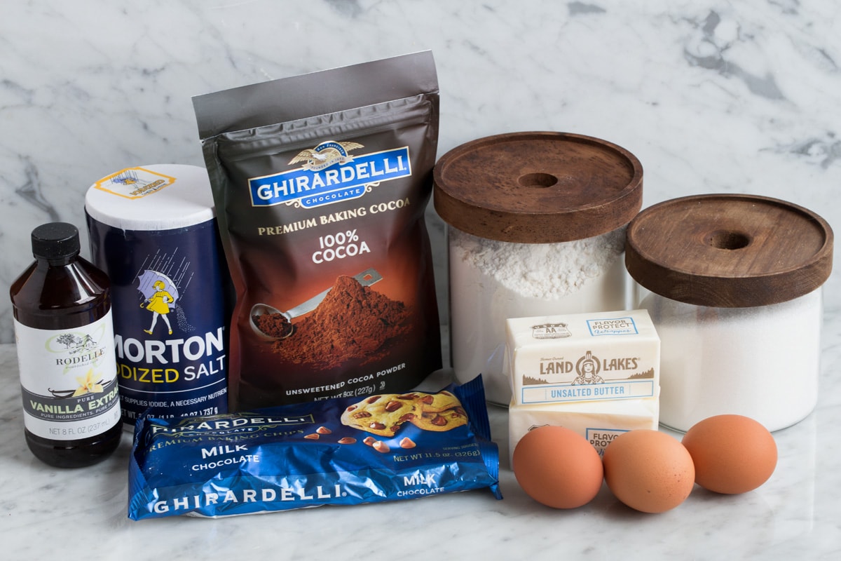 Best Cocoa Brownies Ingredients needed to make brownies shown here including flour, sugar, eggs, butter, cocoa powder, salt, vanilla and chocolate chips.