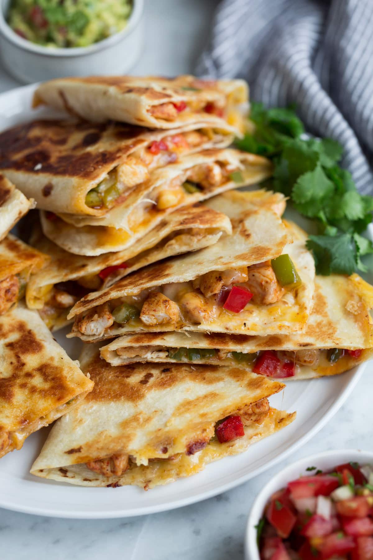 Loaded Quesadillas Quesadillas on a plate served with guacamole and salsa.