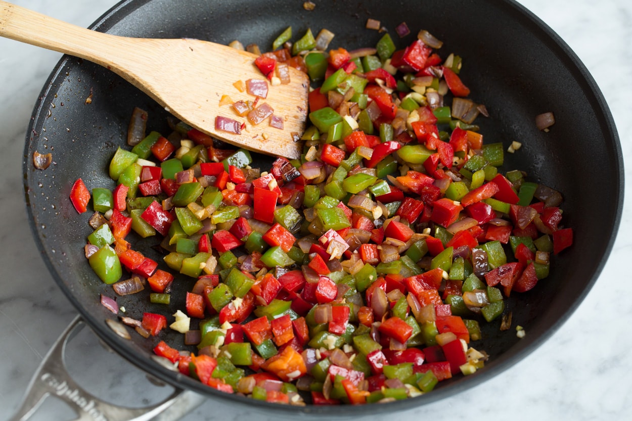 Loaded Chicken Quesadillas Sauteing bell peppers and onions in skillet to use as a filling for quesadillas.