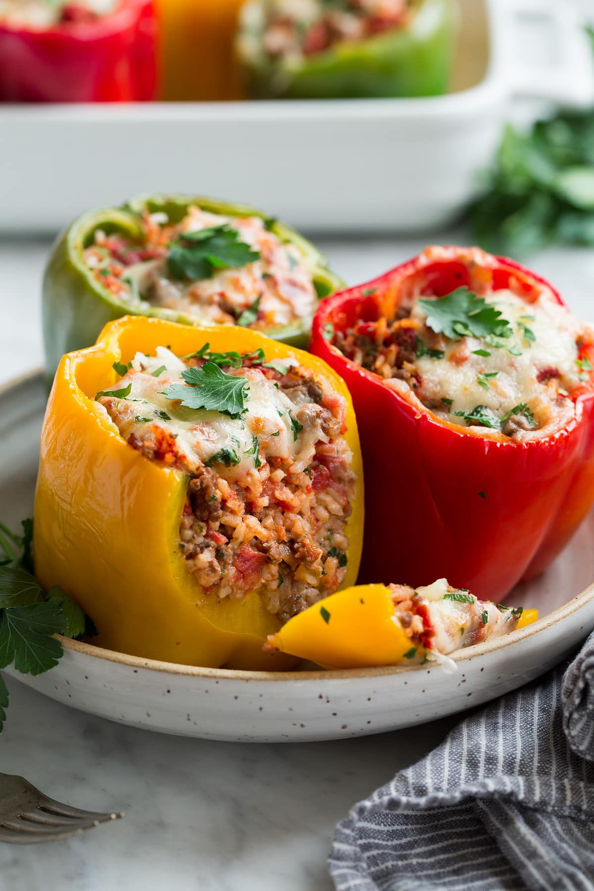 Stuffed Peppers Red yellow and green stuffed pepper in a serving bowl.