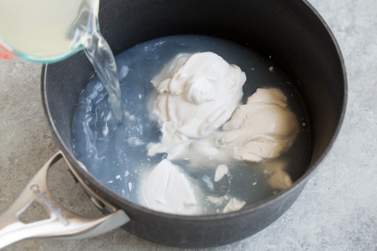 Coconut Rice Recipe Adding water and coconut milk to a medium saucepan.