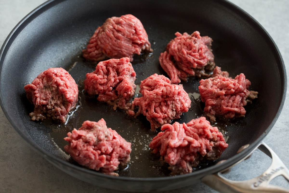Ground Beef Tacos Showing how to make tacos. Searing ground beef in chunks in a non-stick skillet to brown.