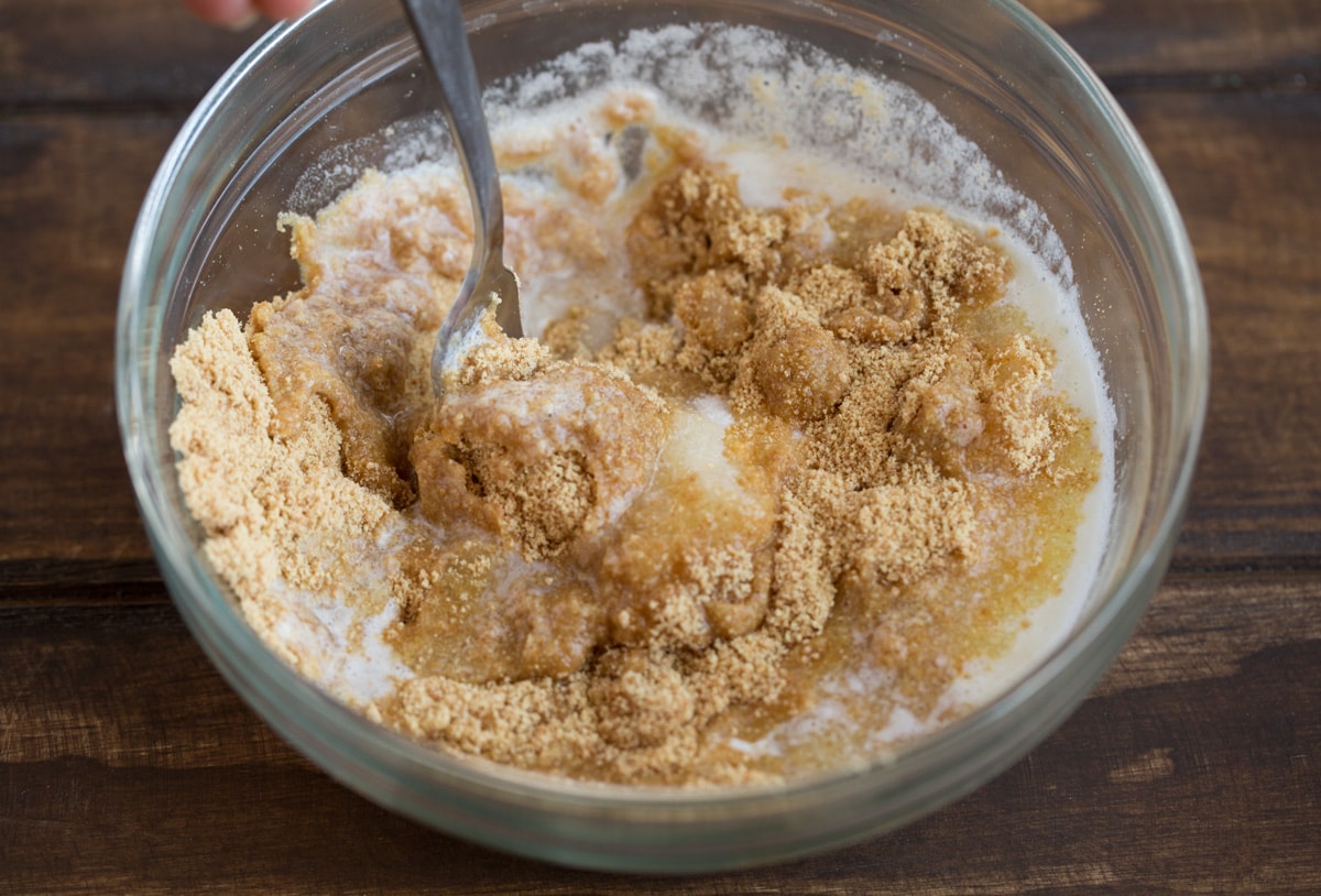 BEST EVER Key Lime Pie recipe! Showing how to make graham cracker crust for key lime pie. Stirring together graham cracker crumbs, butter and sugar in a glass mixing bowl.