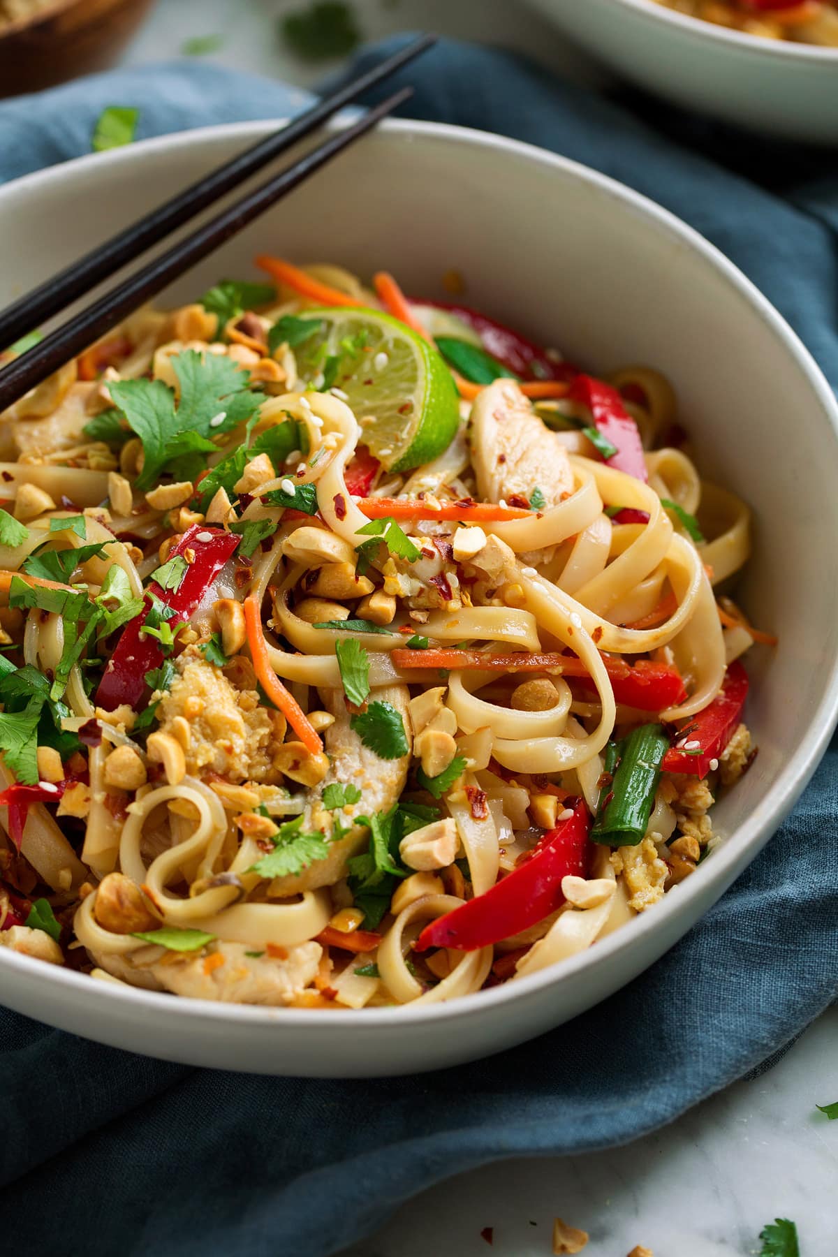 Pad Thai with Chicken or Shrimp Close up image of Pad Thai showing rice noodles, vegetables, chicken, peanuts and cilantro.