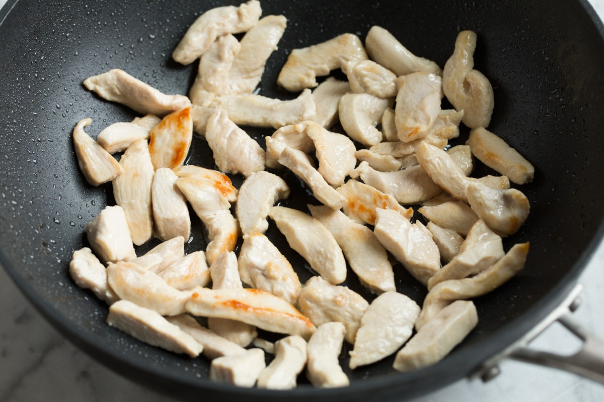 Pad Thai (with Chicken or Shrimp) Showing how to make pad thai. Sautéing chicken breasts pieces in a wok.