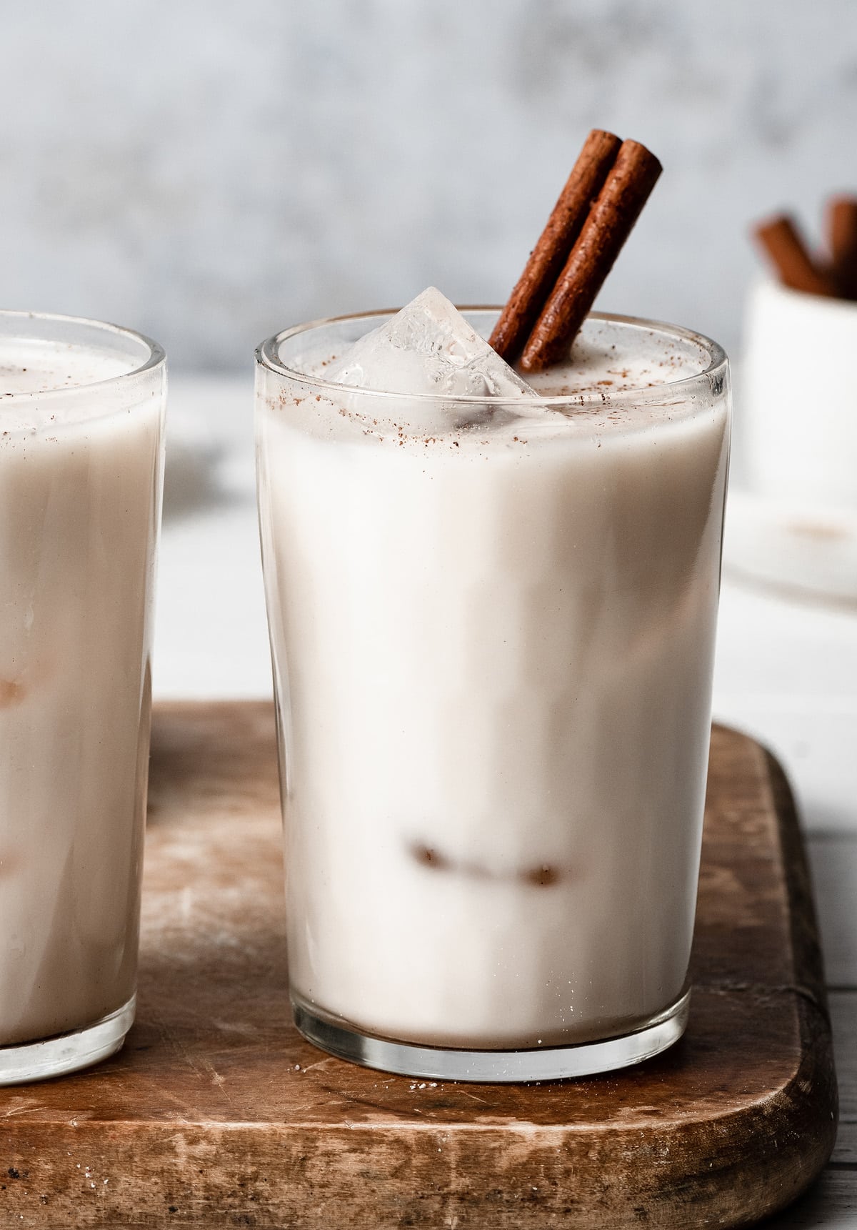 Horchata Close up image of horchata in a glass cup with ice cubes and garnished with a cinnamon stick.