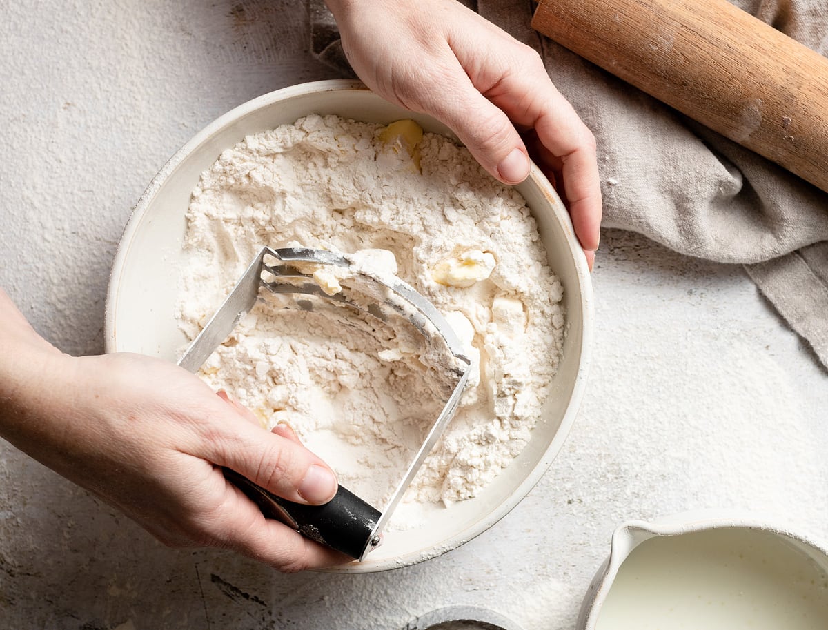 Homemade Buttermilk Biscuits Showing how to make biscuits, cutting butter into flour mixture using a pastry cutter.