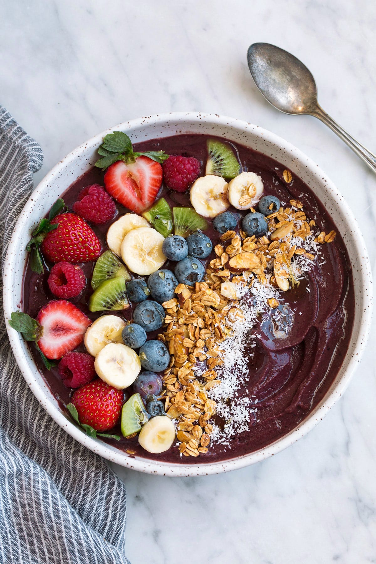 Acai Bowl Acai Bowl topped with fresh fruit, granola and coconut in a large bowl.