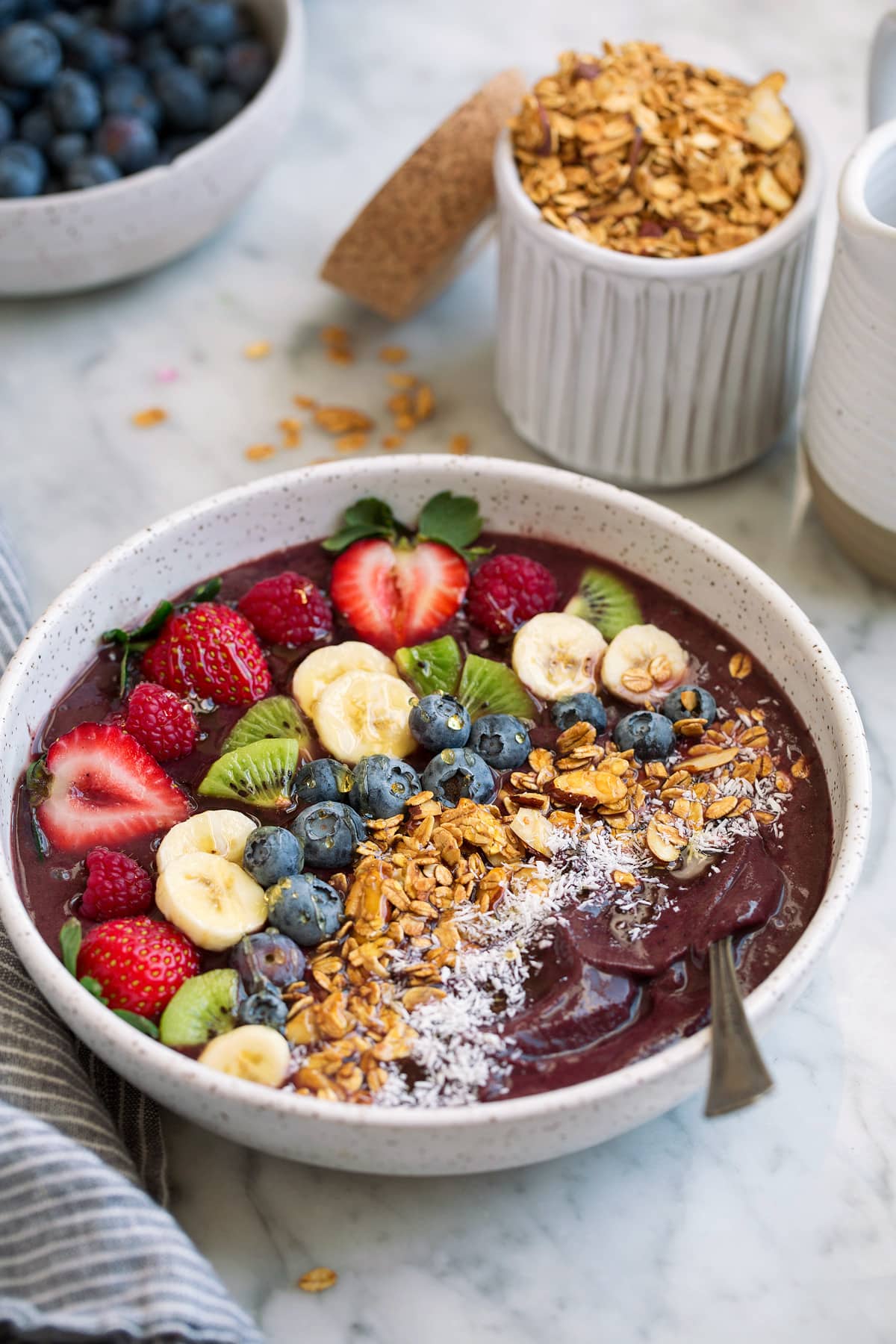 Acai Bowl Acai Bowl topped with fresh fruit, granola and coconut in a large bowl.