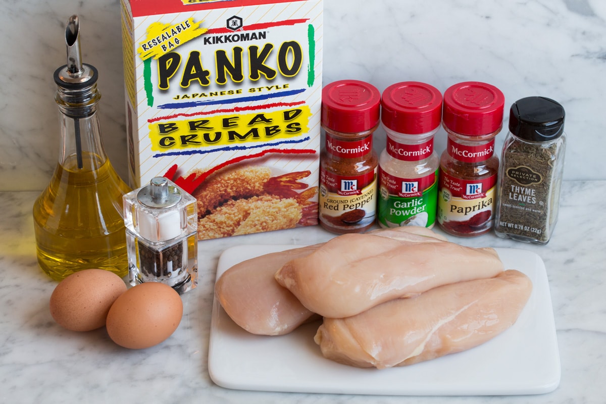 Baked Chicken Nuggets Ingredients needed to make chicken nuggets shown here including chicken breasts, panko, thyme, paprika, garlic powder, cayenne pepper, eggs, olive oil.