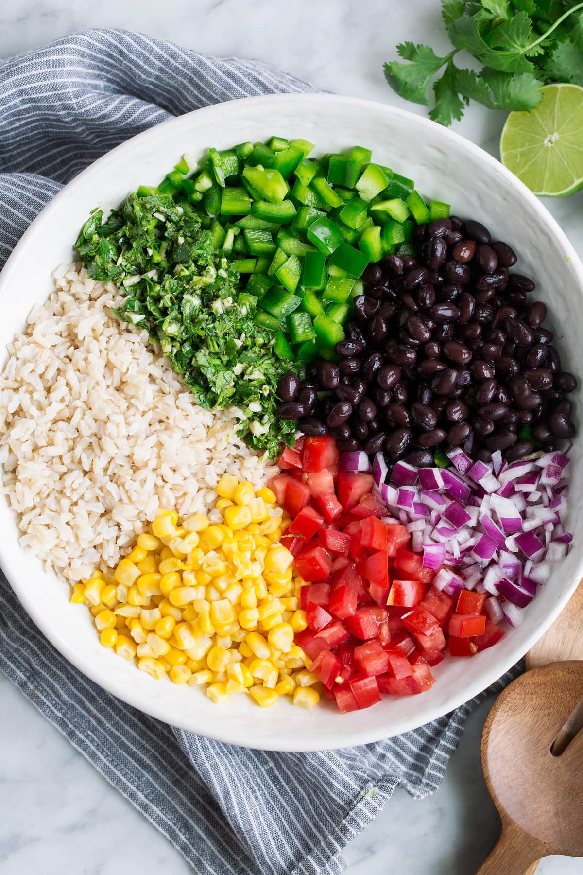 Fiesta Rice - healthy, easy and so flavorful! Perfect side to seafood, chicken and Mexican dishes. Or just eat it on it's own, it's so filling! #rice #ricerecipe #mexican #blackbeans Fiesta Rice Ingredients in a salad bowl before tossing together.
