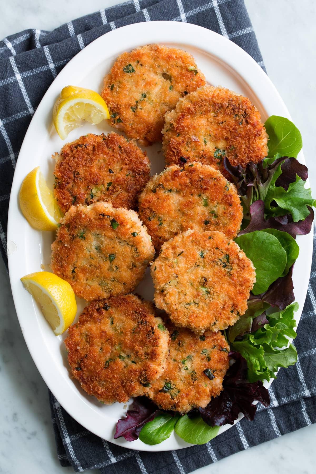 Crispy Salmon Patties (made with fresh salmon, not canned!) Overhead image of eight salmon cakes on a serving platter.