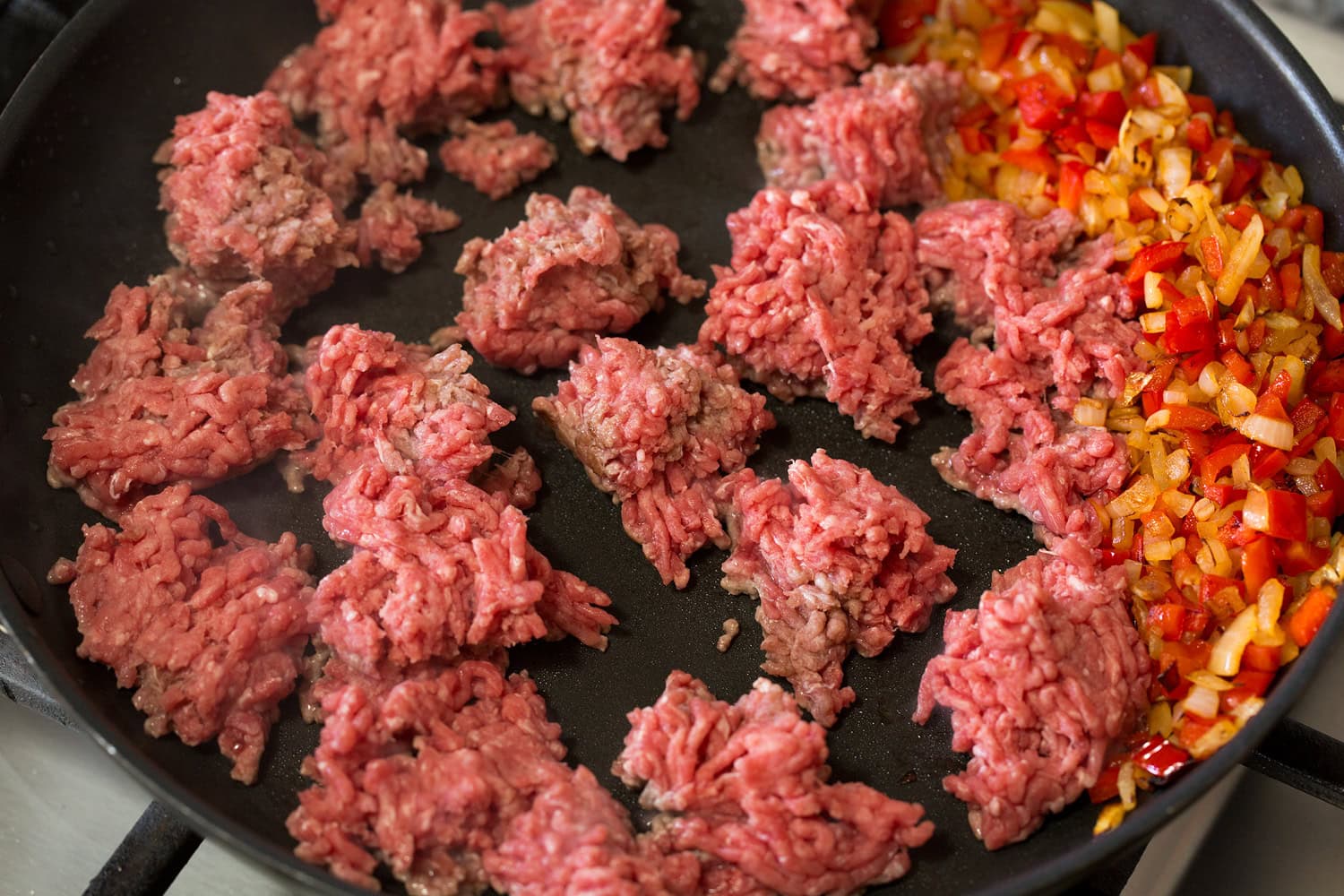Sloppy Joes Ground beef chunks added to skillet with sauteed vegetables.