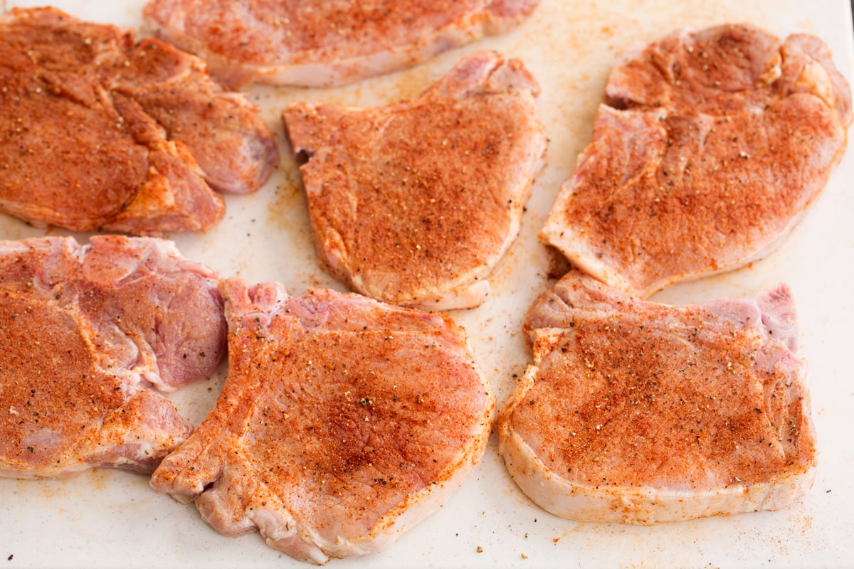 Grilled Pork Chops seven pork chops on a cutting board with dry rub