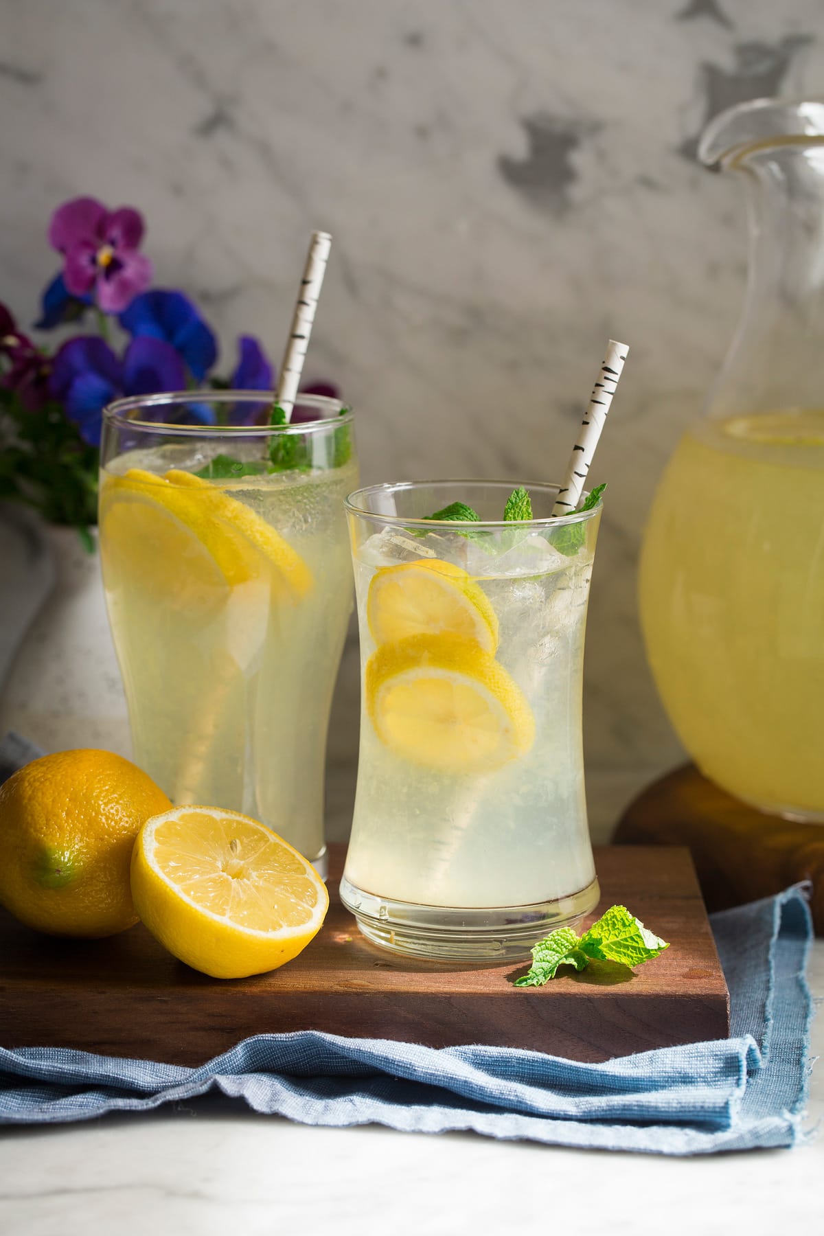 Homemade Lemonade Glass of fresh lemonade in sunshine with flowers in the background.
