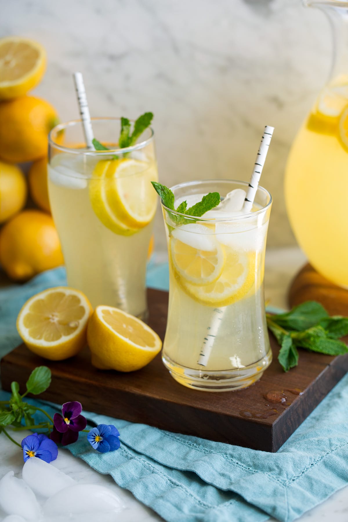Lemonade Two glasses of lemonade on a wooden platter.