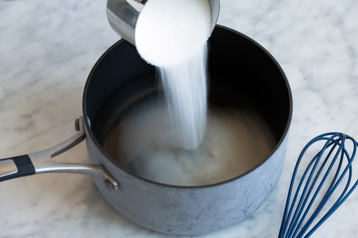 Homemade Lemonade Adding sugar to water in a saucepan.