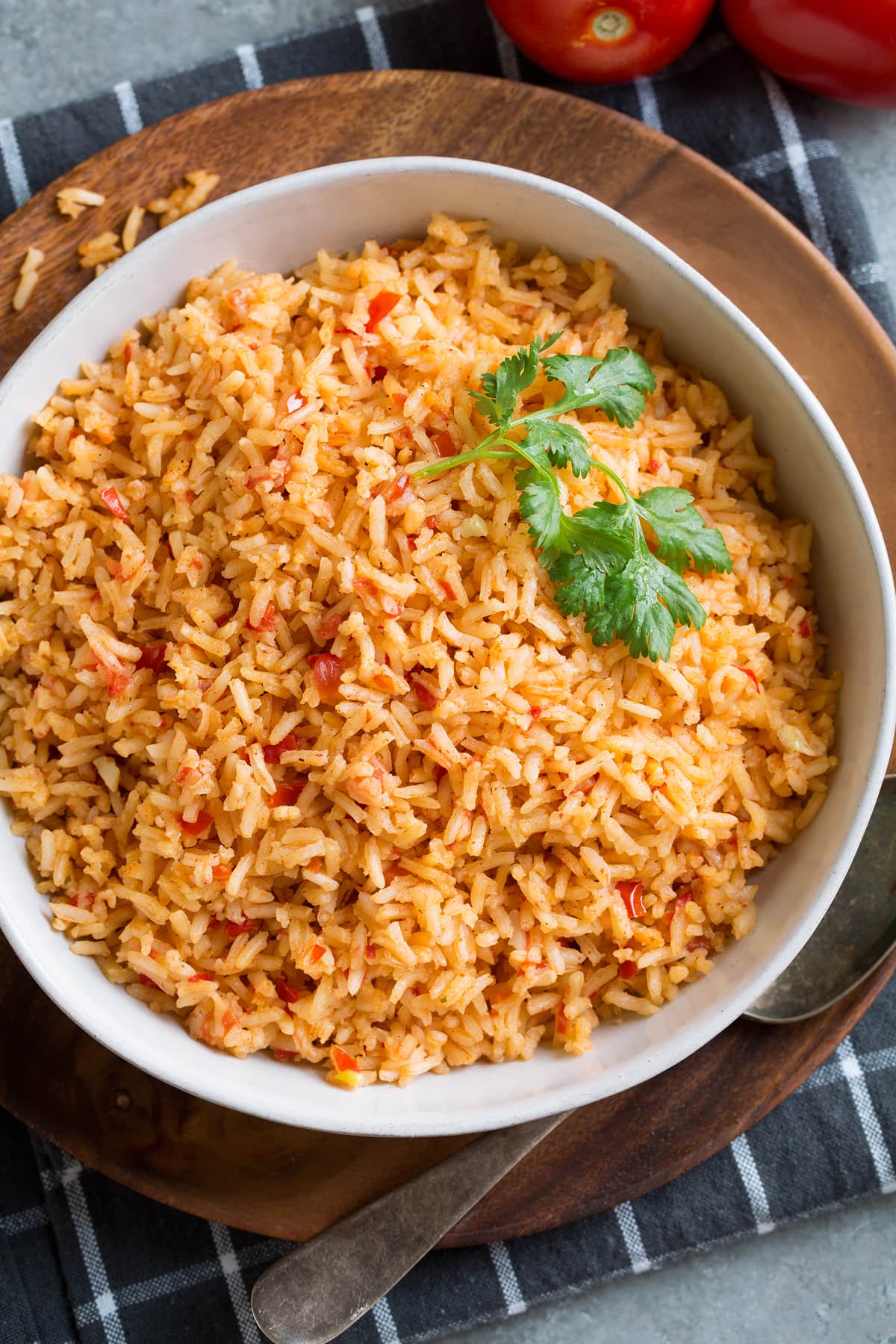 Mexican Rice Mexican rice in a white serving bowl set over a wooden plate.