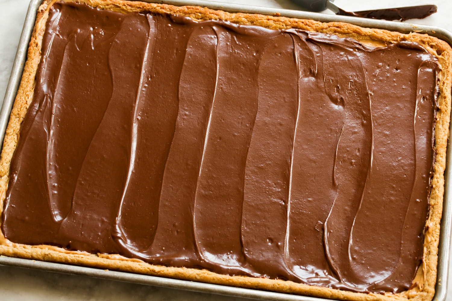 Peanut Butter Bars Chocolate frosting spread over layer of peanut butter.