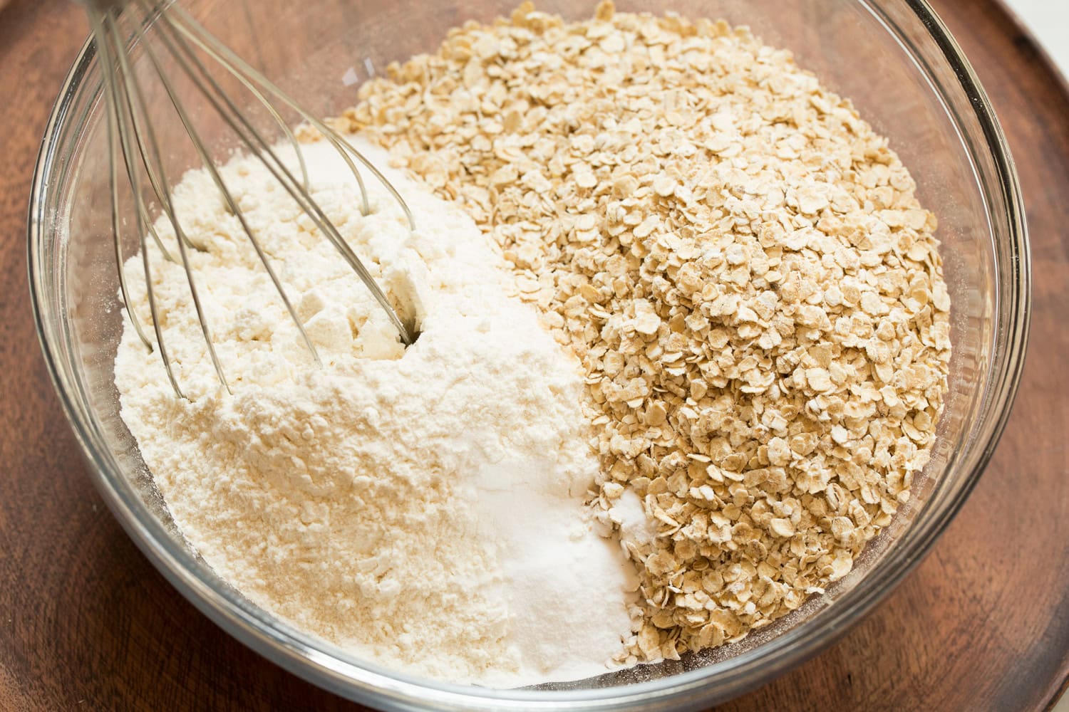Peanut Butter Bars Mixing oats and flour in a glass bowl for cookie bars.