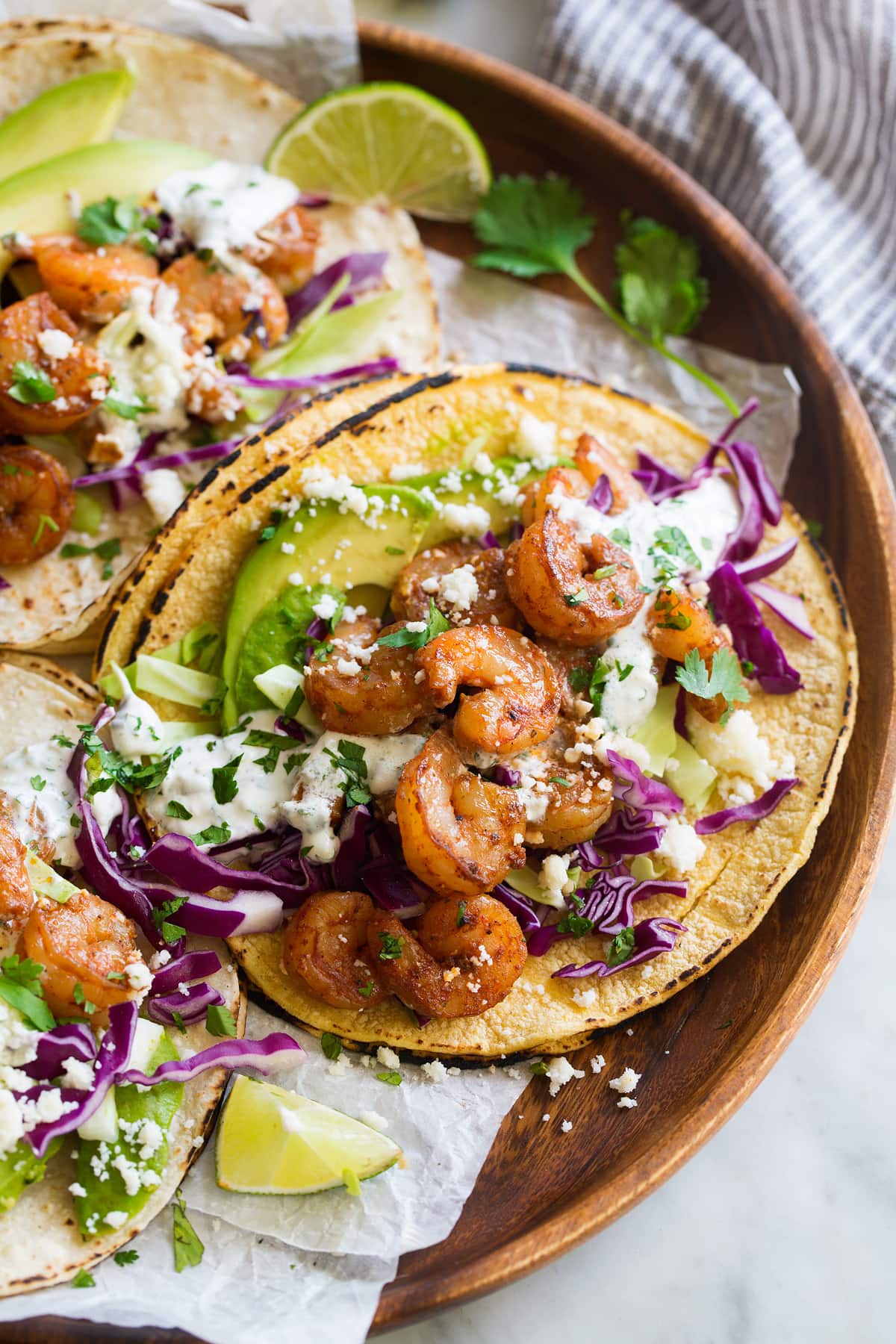 Shrimp Tacos with Cilantro Lime Crema Shrimp Tacos on corn tortillas with cabbage, avocado, cheese and creamy taco sauce.