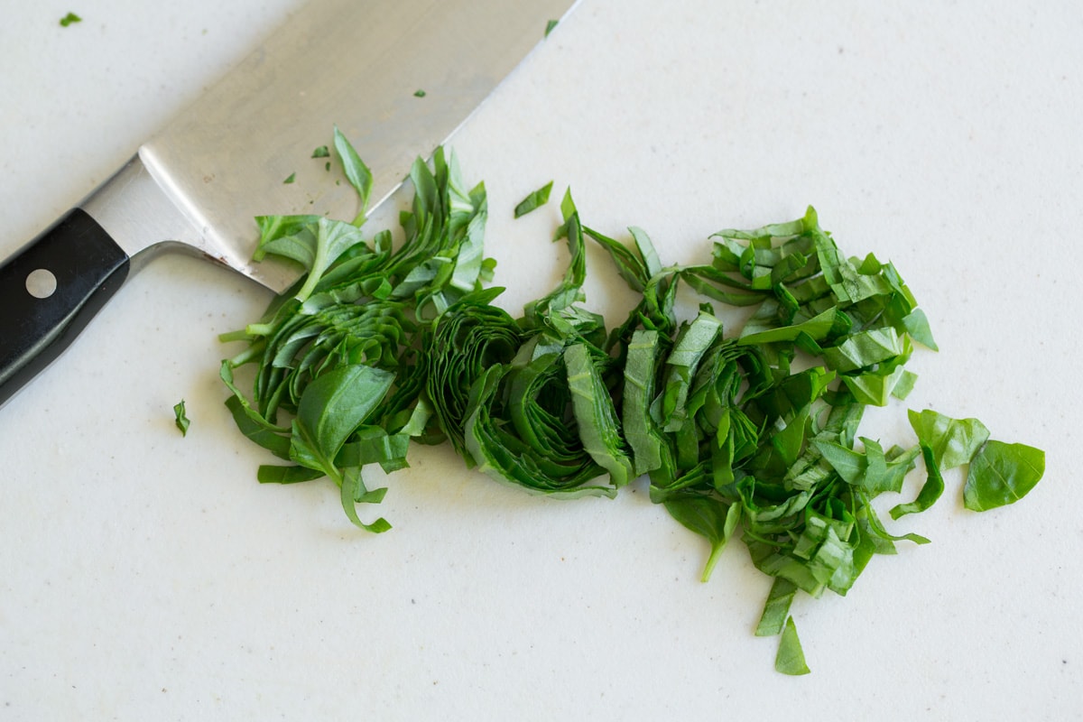 Fresh Bruschetta Chopped basil ribbons on a cutting board