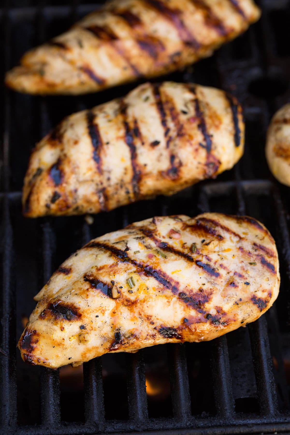 Triple Citrus Chicken Marinade - perfectly bright and refreshing! Total upgrade to plan chicken breasts or thighs. Such a delicious summer recipe! #chicken #marinade #recipe #dinner #grilled Three chicken breasts on a grill.