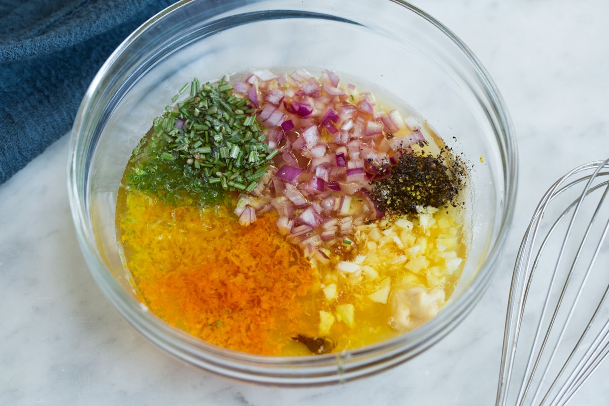Triple Citrus Chicken Marinade - perfectly bright and refreshing! Total upgrade to plan chicken breasts or thighs. Such a delicious summer recipe! #chicken #marinade #recipe #dinner #grilled Showing how to make citrus chicken marinade. Ingredients in a glass mixing bowl with whisk to the side.