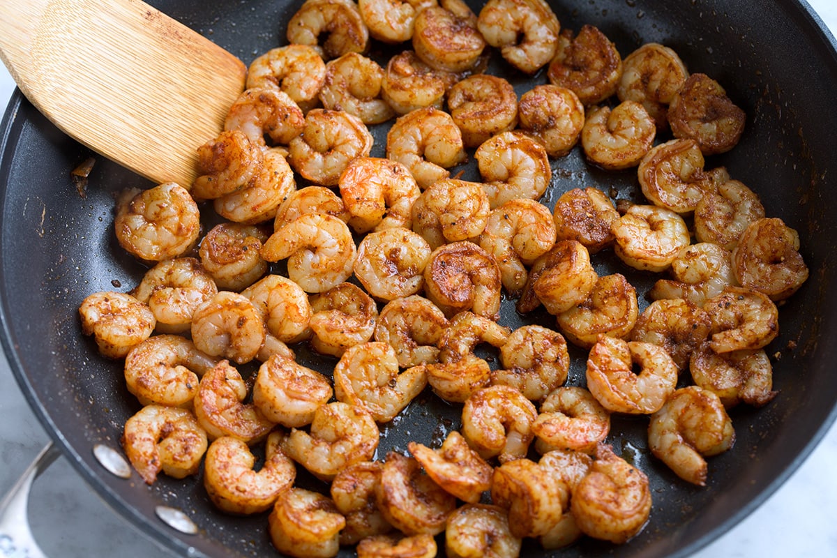 Shrimp Tacos Cooking seasoned shrimp in a skillet.