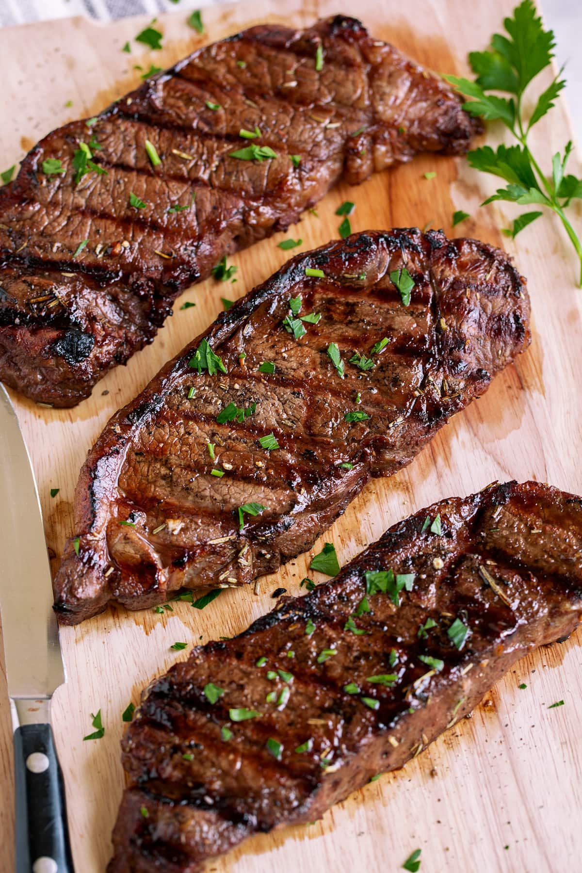 The BEST Steak Marinade! Made with balsamic vinegar and a handful of other pantry staples. A summer must have recipe! #steak #marinade Three marinated grilled steaks.