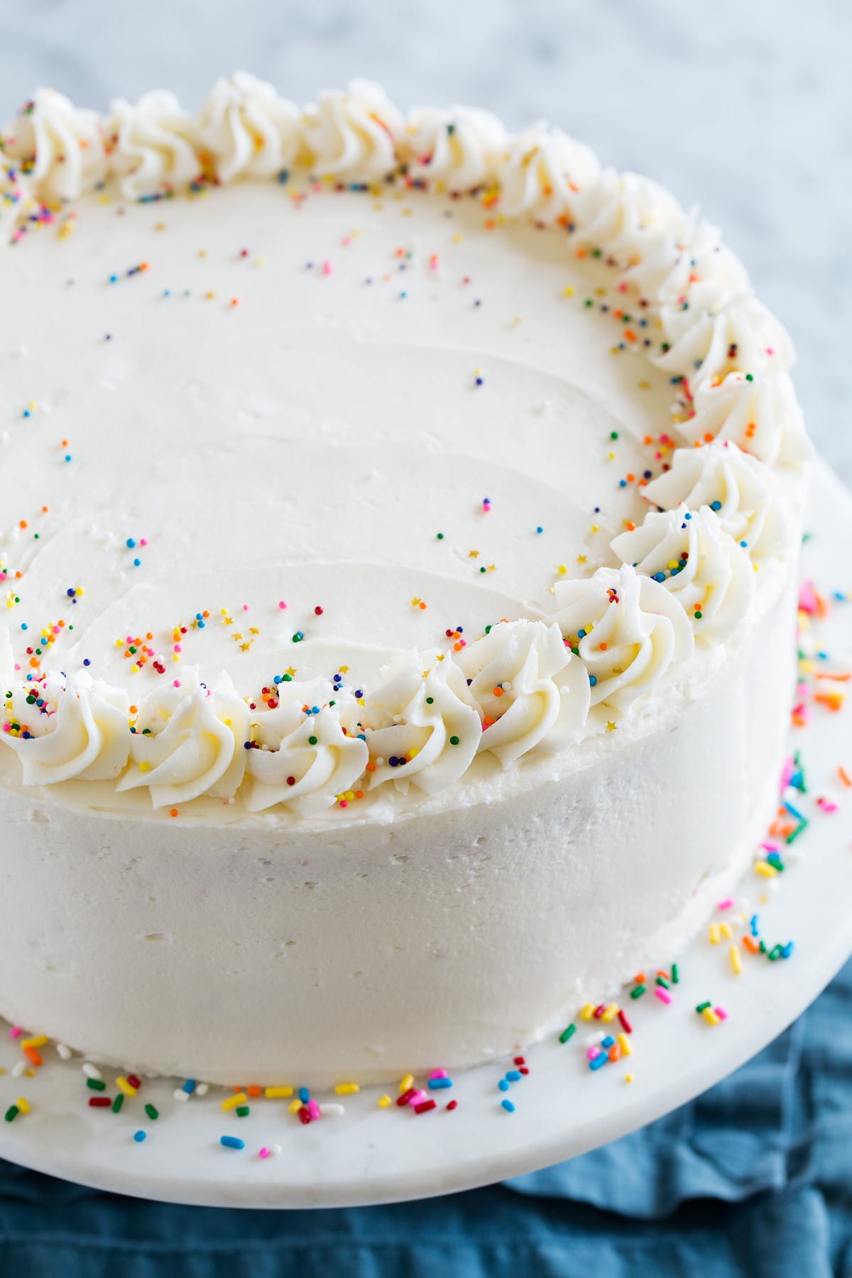 Birthday Cake - the perfect funfetti sprinkled cake! It's perfectly soft and fluffy and amazingly delicious! My kids absolute favorite cake! #cake #birthdaycake #dessert #birthday Close up image of a whole funfetti birthday cake