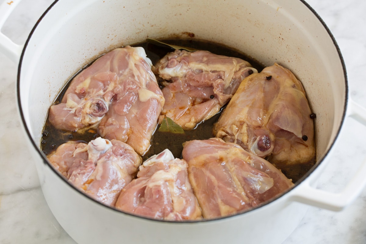 Chicken Adobo - easy Filipino chicken recipe made with soy sauce, vinegar, garlic and a hint of brown sugar. Tastes similar to teriyaki sauce but not quite so sweet. A perfect weeknight dinner! #chicken #adobo #recipe Six chicken thighs in adobo sauce before cooked.