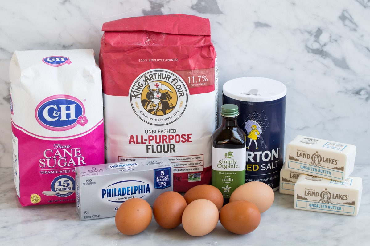 Pound Cake Ingredients to make pound cake shown here including flour, sugar, butter, cream cheese, eggs, salt and vanilla.