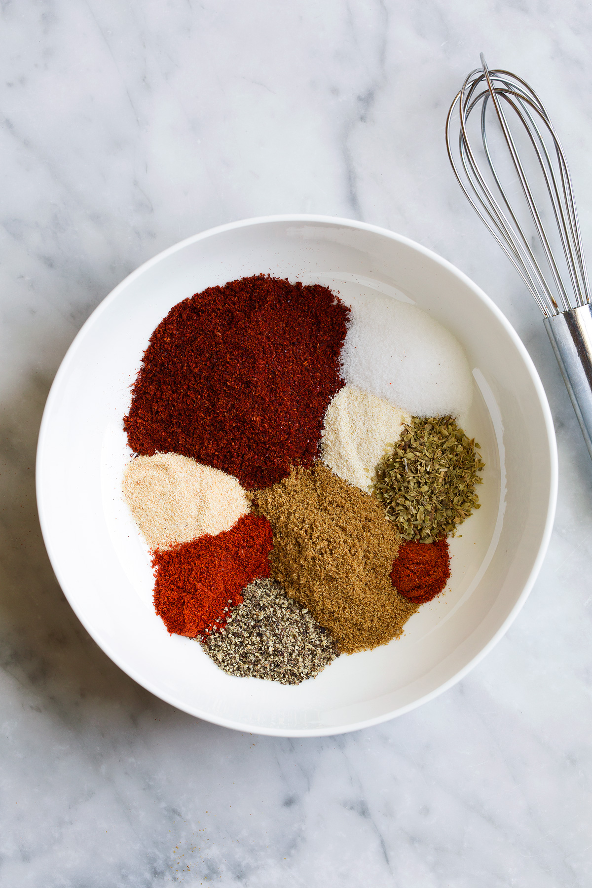 Homemade Taco Seasoning Taco seasoning in a mixing bowl showing all the spices separately before mixing.