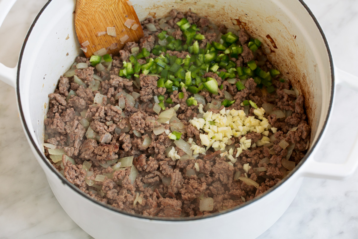 Taco Soup - easy, incredibly tasty soup! Loaded with hearty ingredients and brimming with delicious seasoned flavor. Perfect for cold fall and winter days! #tacosoup #soup #fall #recipe Browning beef, garlic, onion and jalapeno in a pot to make taco soup.