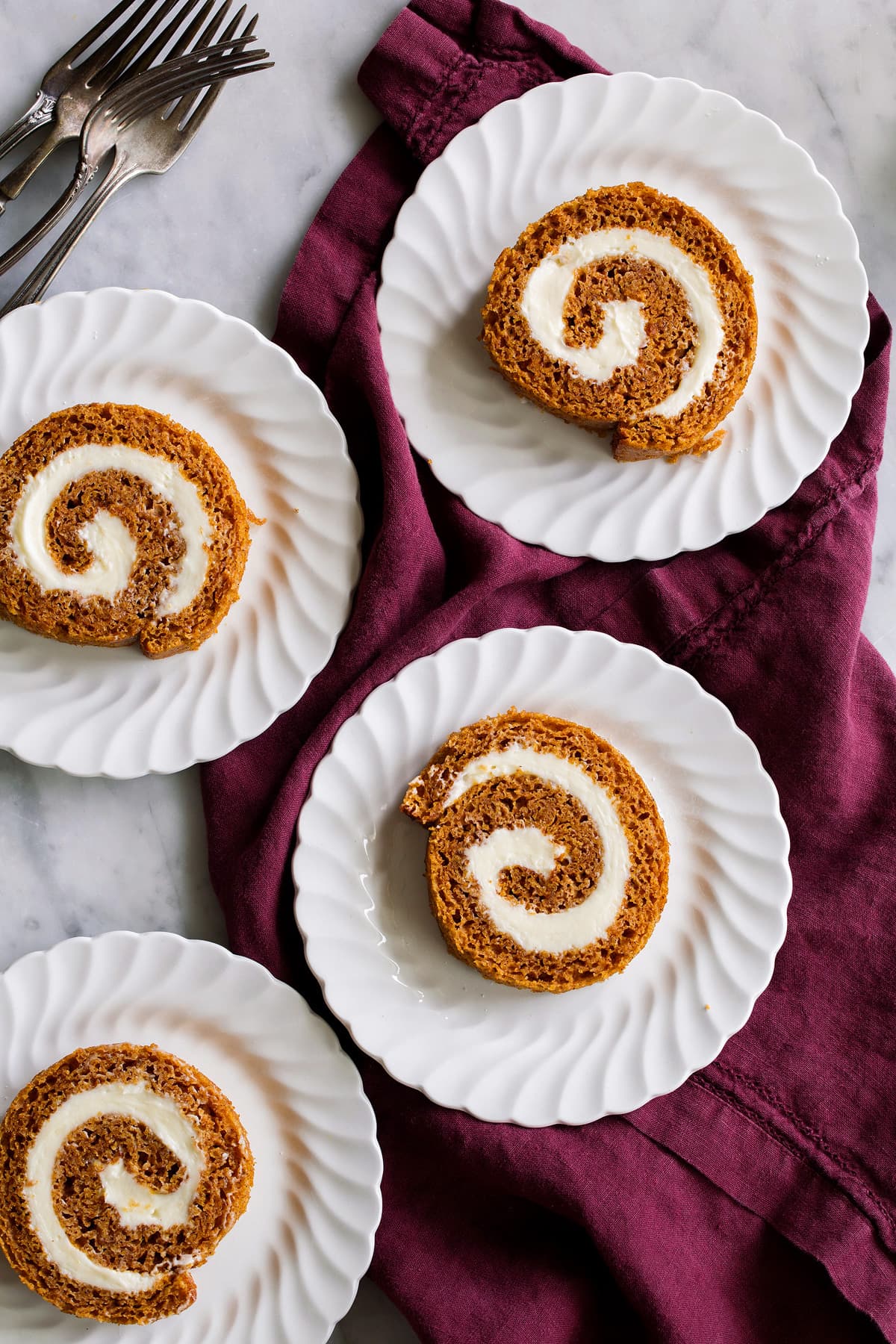 Pumpkin Roll Four slices of pumpkin roll on a dessert plate.