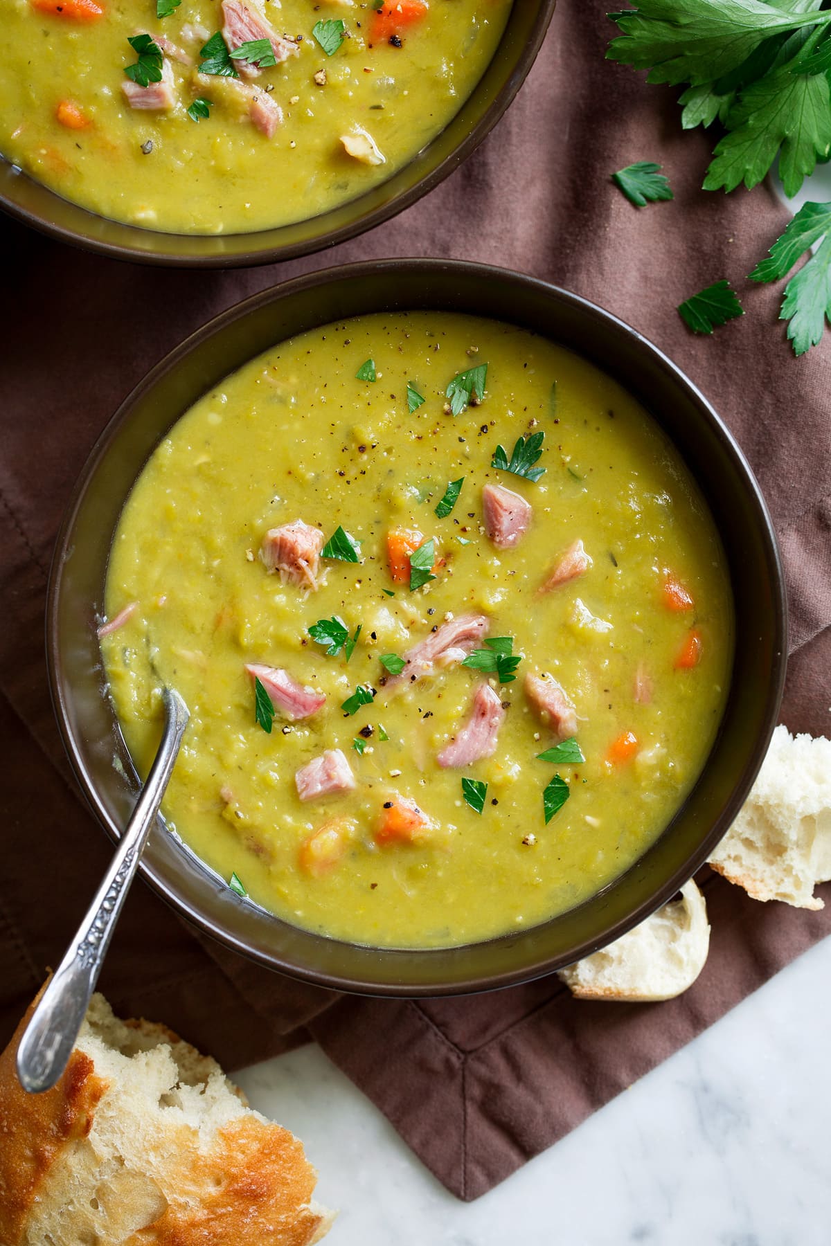 Split Pea Soup - such a delicious and comforting soup. This made from scratch version is a hundred times better than what you get in the can and it's so easy to make! #splitpea #soup #recipe Overhead image of two bowls of made from scratch split pea soup.