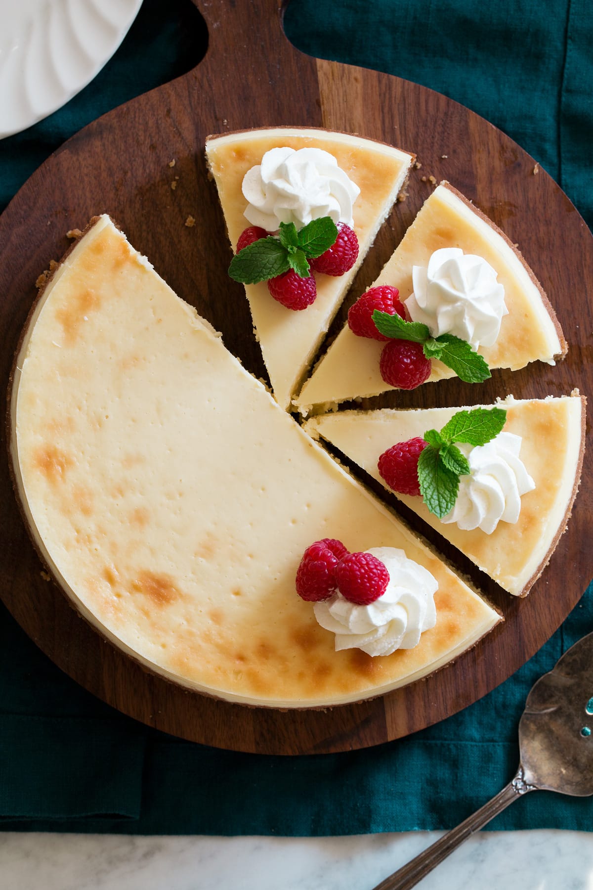 The BEST Cheesecake Recipe! Overhead image of sliced cheesecake.