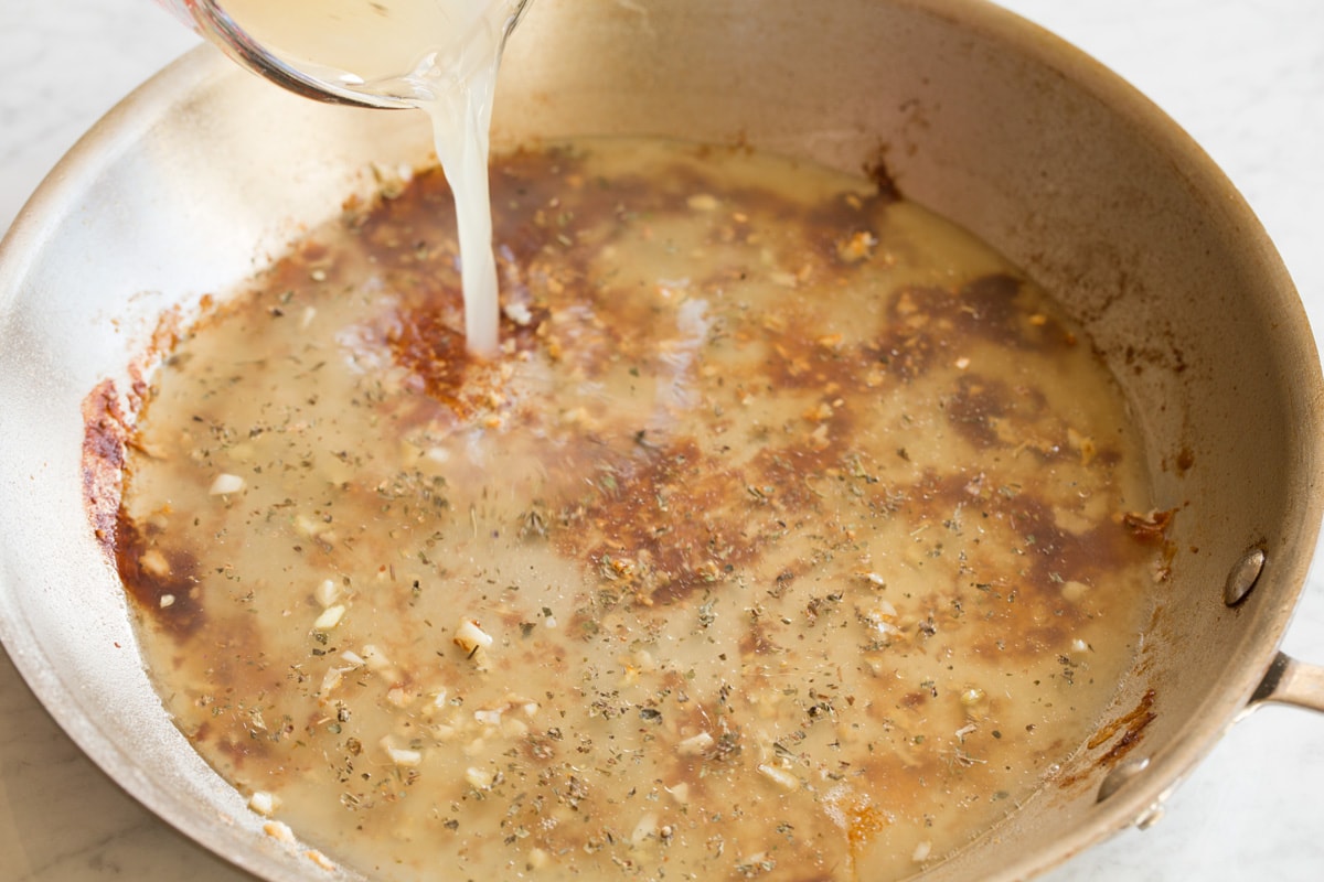 Creamy Lemon Romano Chicken Pour chicken broth into skillet.