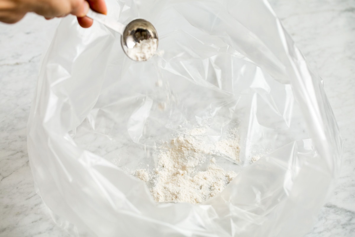 How to Cook a Turkey Adding flour to an oven bag.
