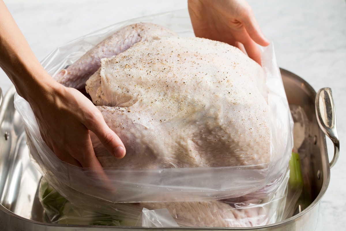 How to Cook Turkey {in an Oven Bag} Putting turkey in an oven bag in a roasting pan.