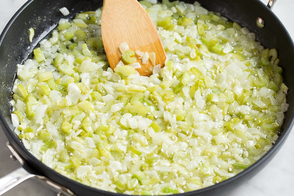 Stuffing Recipe - this is my FAVORITE stuffing! It's perfectly moistened in the center, browned and crisp on the edges and packed with butter and herb flavor. A fall staple! #stuffing #thanksgiving #sidedish #recipe Sautéing celery, onions and garlic in a skillet with butter.
