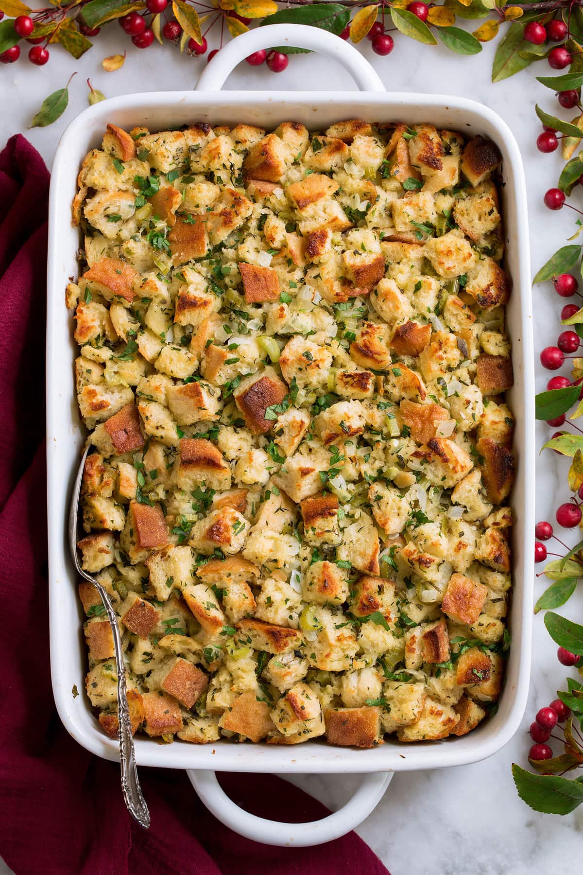 Stuffing Recipe - this is my FAVORITE stuffing! It's perfectly moistened in the center, browned and crisp on the edges and brimming with butter and herb flavor. A fall staple! #stuffing #thanksgiving #sidedish #recipe Stuffing in a white casserole dish.